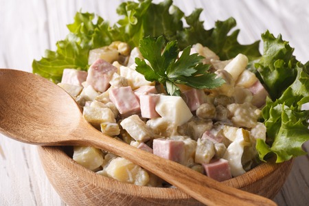 Russian salad close up in a wooden bowl on the table. horizontalの写真素材