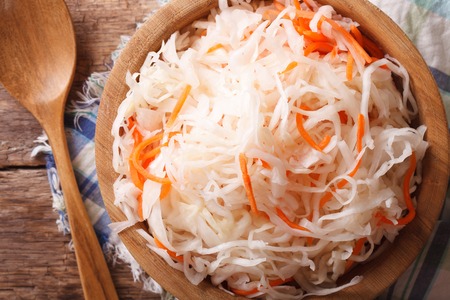 sauerkraut and carrots in a wooden plate macro. horizontal view from above, rustic styleの写真素材