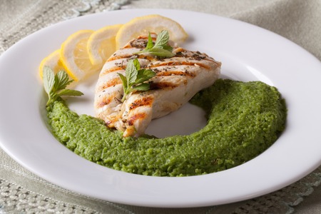 Grilled chicken and mashed mint with green peas close-up on a white plate. horizontalの写真素材