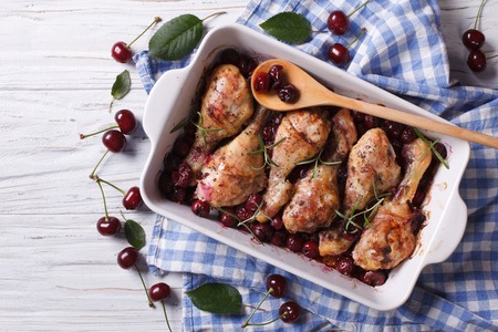 Baked chicken legs in cherry sauce and rosemary close up. Horizontal top viewの写真素材