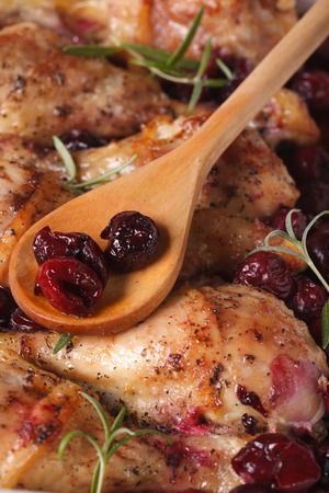 Baked chicken leg with cherry and rosemary macro. verticalの写真素材
