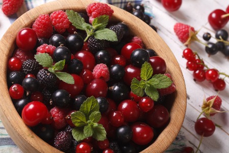 Salad of fresh berries in a wooden bowl closeup. horizontalの写真素材