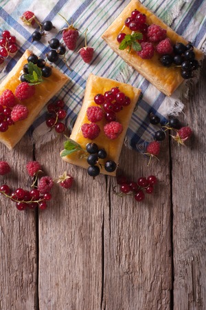 Delicious cookies with berries, honey and mint on a table. vertical top viewの写真素材