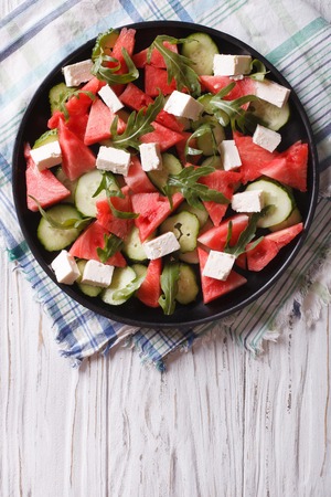 salad with feta, watermelon, cucumber and arugula on the table. vertical top viewの写真素材