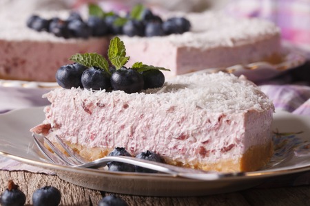 A piece of delicious blueberry cheesecake with fresh berries and coconut macro on a plate. horizontalの写真素材