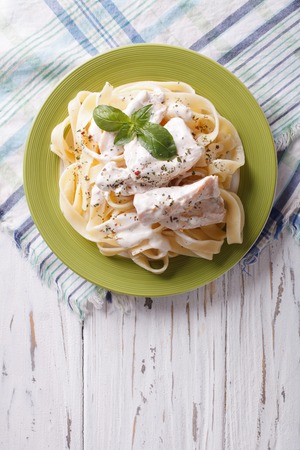 alfredo pasta in cream sauce with chicken on a plate. vertical top viewの写真素材