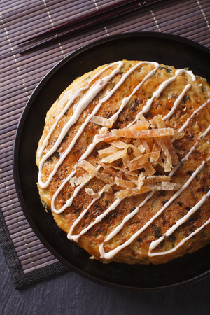 Japanese okonomiyaki pizza close-up on a plate. vertical top viewの写真素材