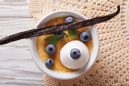 Creme brulee dessert with blueberries close-up on the table. horizontal view from above