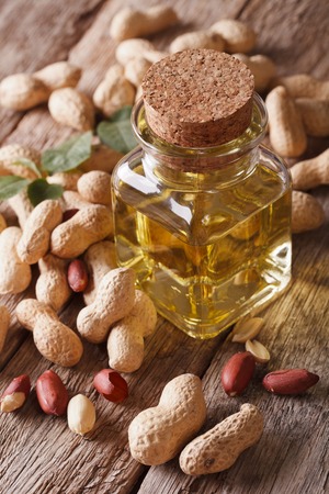 peanut oil in a glass jar on a wooden table close-up. verticalの写真素材