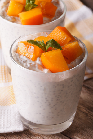 Yogurt with chia seeds and persimmon close-up on the table.の写真素材
