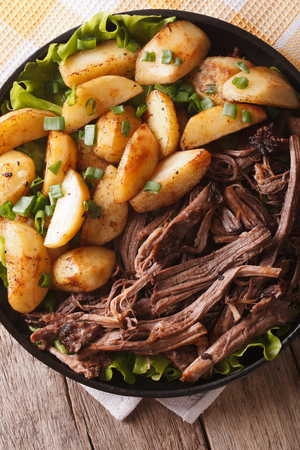 Hot Pulled pork with baked potatoes close-up on a plate. vertical top viewの写真素材