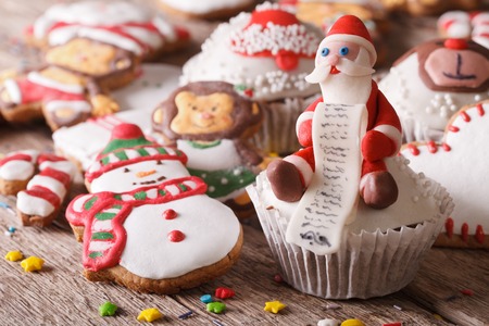 Christmas cupcakes and gingerbread cookies close-up on a wooden table. Horizontalの写真素材