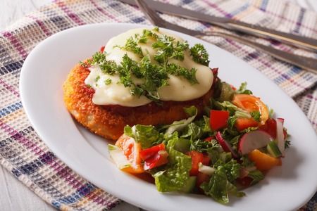 Italian food: Chicken Parmigiana and salad close up on a plate on the table. Horizontalの写真素材