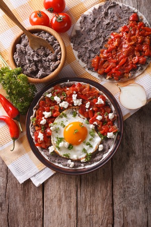 Mexican breakfast: huevos rancheros on the plate on the table. vertical view from aboveの写真素材