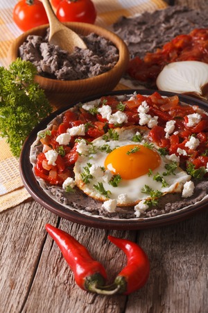 Mexican breakfast: huevos rancheros close-up on a plate on the table. verticalの写真素材