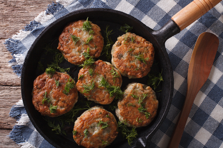 fish cakes with herbs close-up in a frying pan. horizontal view from aboveの写真素材