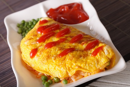 Japanese cuisine: Omurice with rice, green peas and ketchup close-up on a plate. Horizontalの写真素材