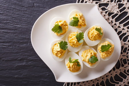Stuffed eggs with mustard and parsley on a plate. Horizontal top view