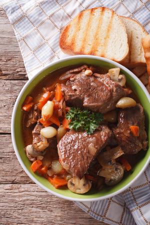 Rustic Beef Bourguignon in a bowl on a table close-up. vertical view from aboveの写真素材
