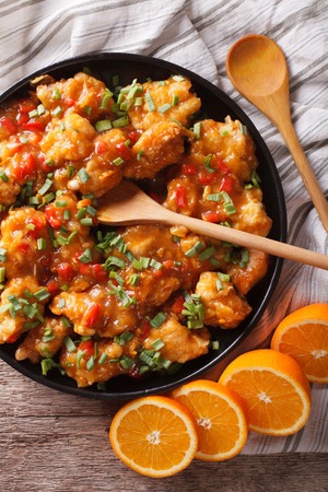 orange chicken closeup on a plate on the table. vertical view from above, rustic styleの写真素材
