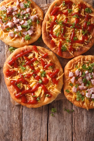 Hungarian hot langos with cheese, ketchup and ham close-up on the table. vertical view from aboveの写真素材