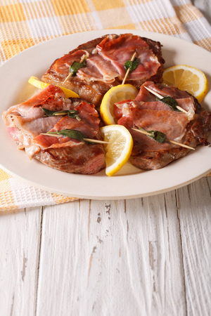 Beef Saltimbocca with sage and ham close-up on a plate. Verticalの写真素材
