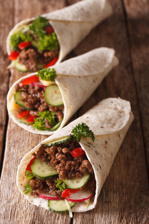 Burritos with minced meat and fresh vegetables close-up on the table. verticalの写真素材