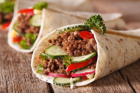 Sandwich roll with beef and fresh vegetables macro on the table. Horizontalの写真素材