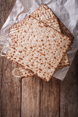 Jewish kosher matzah closeup on paper on a wooden table. vertical view from aboveの写真素材