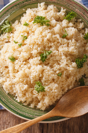 Bulgur with parsley macro on a plate on the table. vertical view from aboveの写真素材