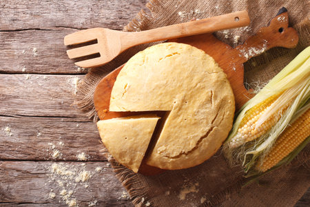 Delicious freshly baked corn bread close-up on a wooden board. Horizontal view from above