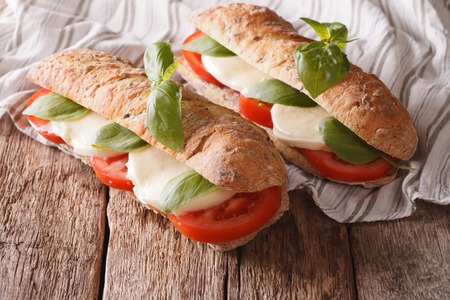 Italian sandwiches with fresh tomatoes, mozzarella cheese and basil close-up on the table. horizontalの写真素材