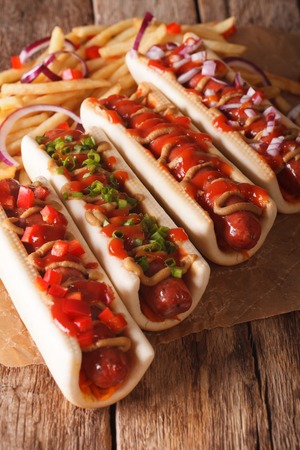 Simple food: hot dogs and french fries closeup of paper on the table. verticalの写真素材