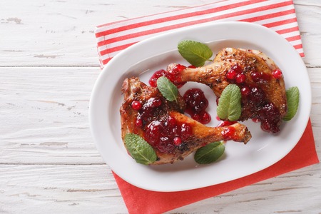 Christmas food: baked duck leg with cranberry sauce and mint closeup on a plate. horizontal view from aboveの写真素材