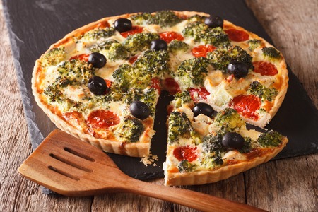 savory tart with chicken, broccoli, tomatoes and olives close-up on the table. horizontalの写真素材