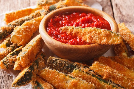 zucchini sticks breaded with parmesan and tomato sauce closeup on a table. horizontalの写真素材