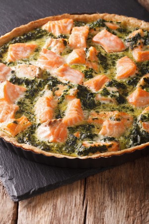 Tasty Savory Tart with salmon and spinach in the dish for baking close-up on the table. vertical
の写真素材