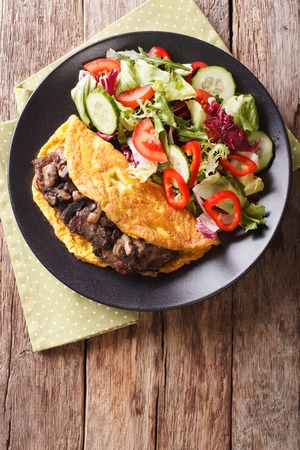Austrian Imperial Steak with mushrooms, scrambled eggs and fresh salad on the plate closeup. vertical view from above
の写真素材