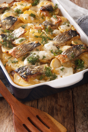 Finnish cuisine: kalalaatikko with potatoes and herring close up in baking dish. verticalの写真素材