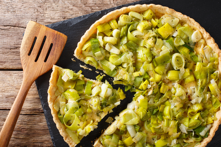 Sliced savory leek tart with cheese close-up on the table. Horizontal view from aboveの写真素材