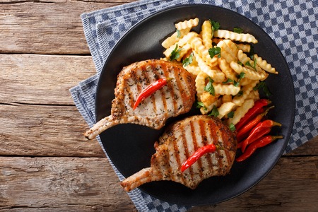 Barbecue spicy pork chop with chili and french fries close-up. horizontal view from aboveの写真素材