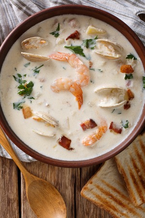 New England clam chowder soup close-up on the table. Vertical view from aboveの写真素材