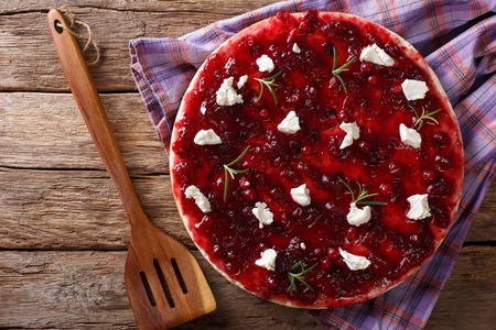 Pizza with cranberry sauce, goat cheese and rosemary close-up on the table. Horizontal view from aboveの写真素材