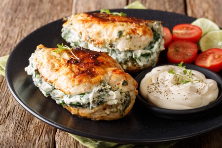 Baked Chicken fillet stuffed with cheese and spinach with sauce close-up on a plate. horizontalの写真素材