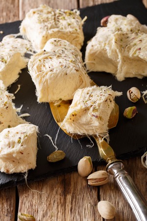 Turkish food: fresh dessert pismaniye with nuts pistachios close-up on the table. verticalの写真素材