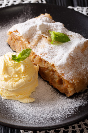 Austrian traditional apple strudel with ice cream and mint closeup on a plate. verticalの写真素材