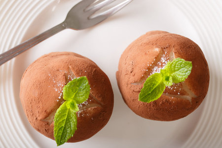 Traditional rum balls cake with mint and cocoa powder close-up on a plate. horizontal view from...