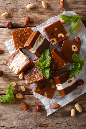 Caramel candy with nuts close-up on the table. vertical view from aboveの写真素材