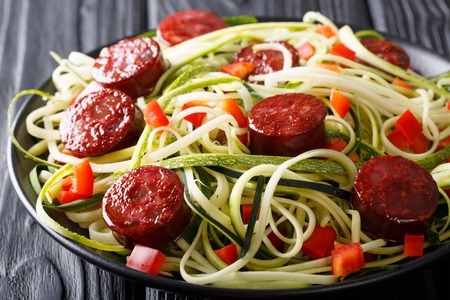 Zucchini pasta with fresh pepper and fried sausages close-up on the table. horizontalの写真素材