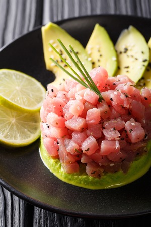 Tartar from tuna served with avocado and lime macro on a plate. verticalの写真素材